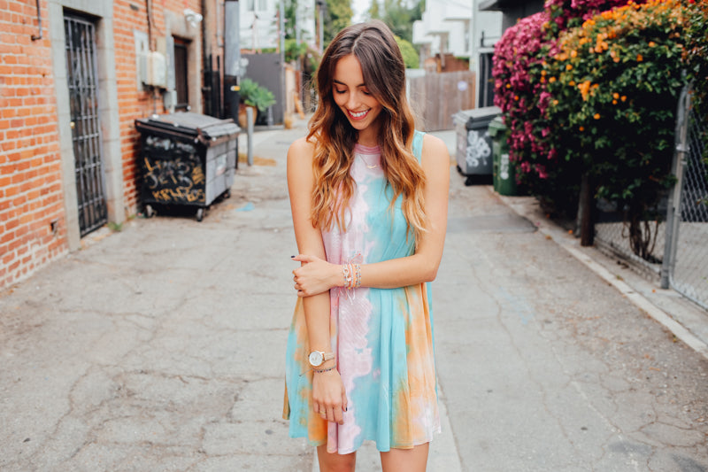 Pastel tie dye Sand Dune tank dress styled with Pura Vida bracelets in an urban alley.