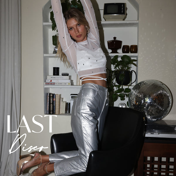 Last Disco bachelorette look pairing a sheer rhinestone top with metallic silver pants by a disco ball.