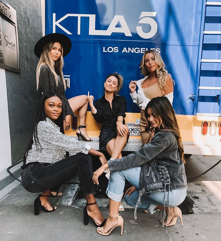 12th Tribe team posing in stylish outfits beside the KTLA 5 Los Angeles news truck.
